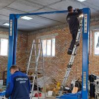 Установка двухстоечного подъемника с верхней синхронизацией с электростопорами